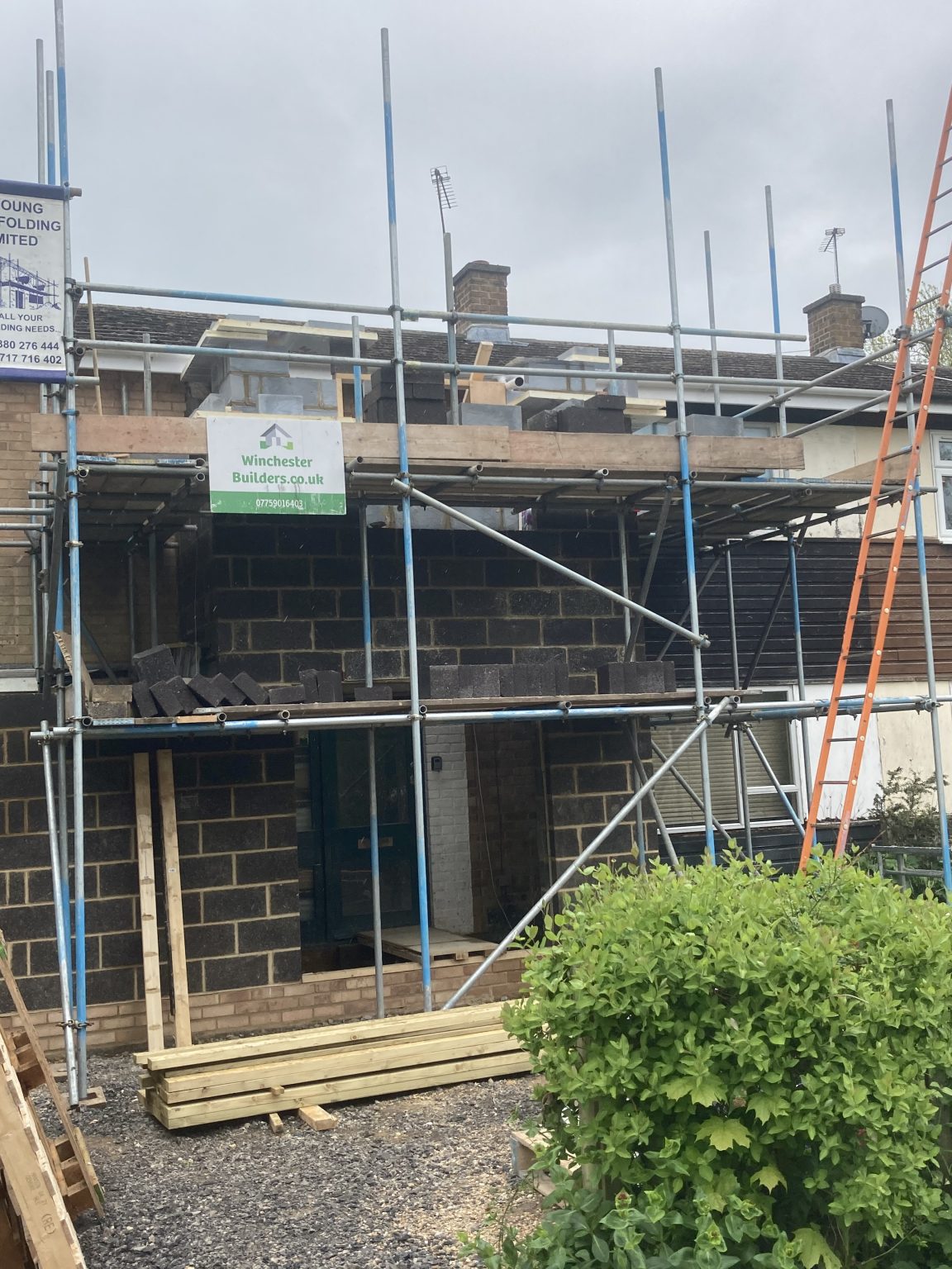 Extension brickwork rising inside a scaffold