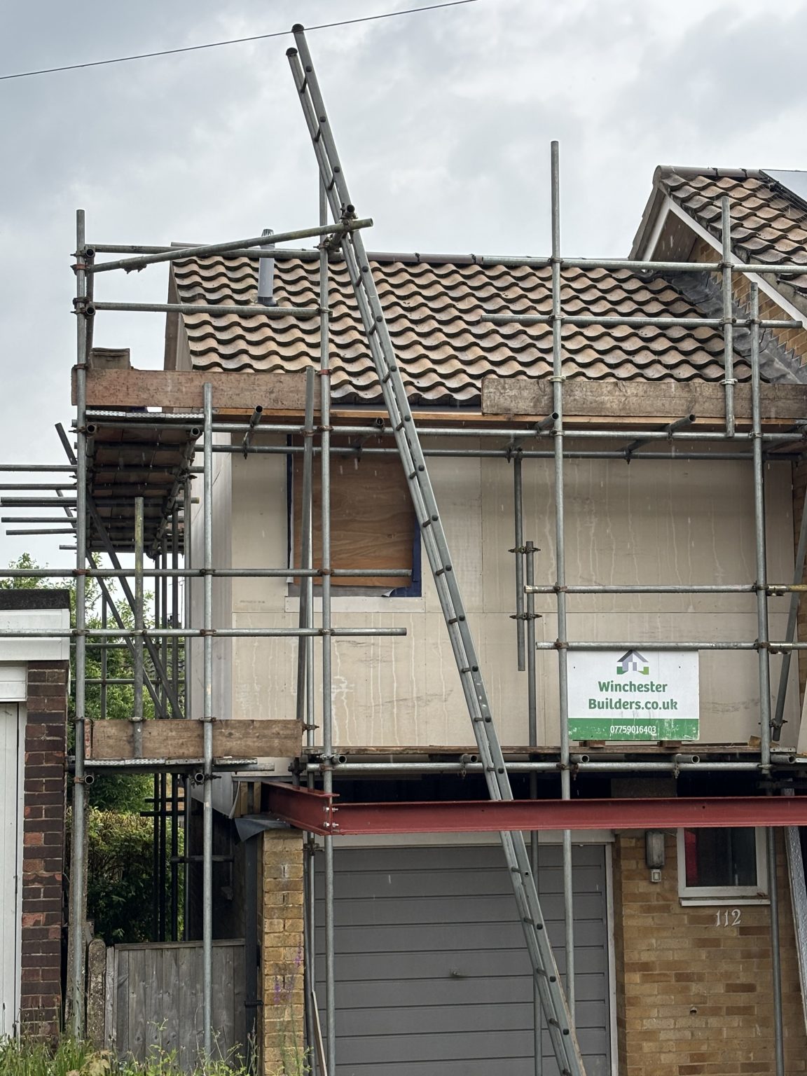 Re-roofing in progress with scaffold and ladder access