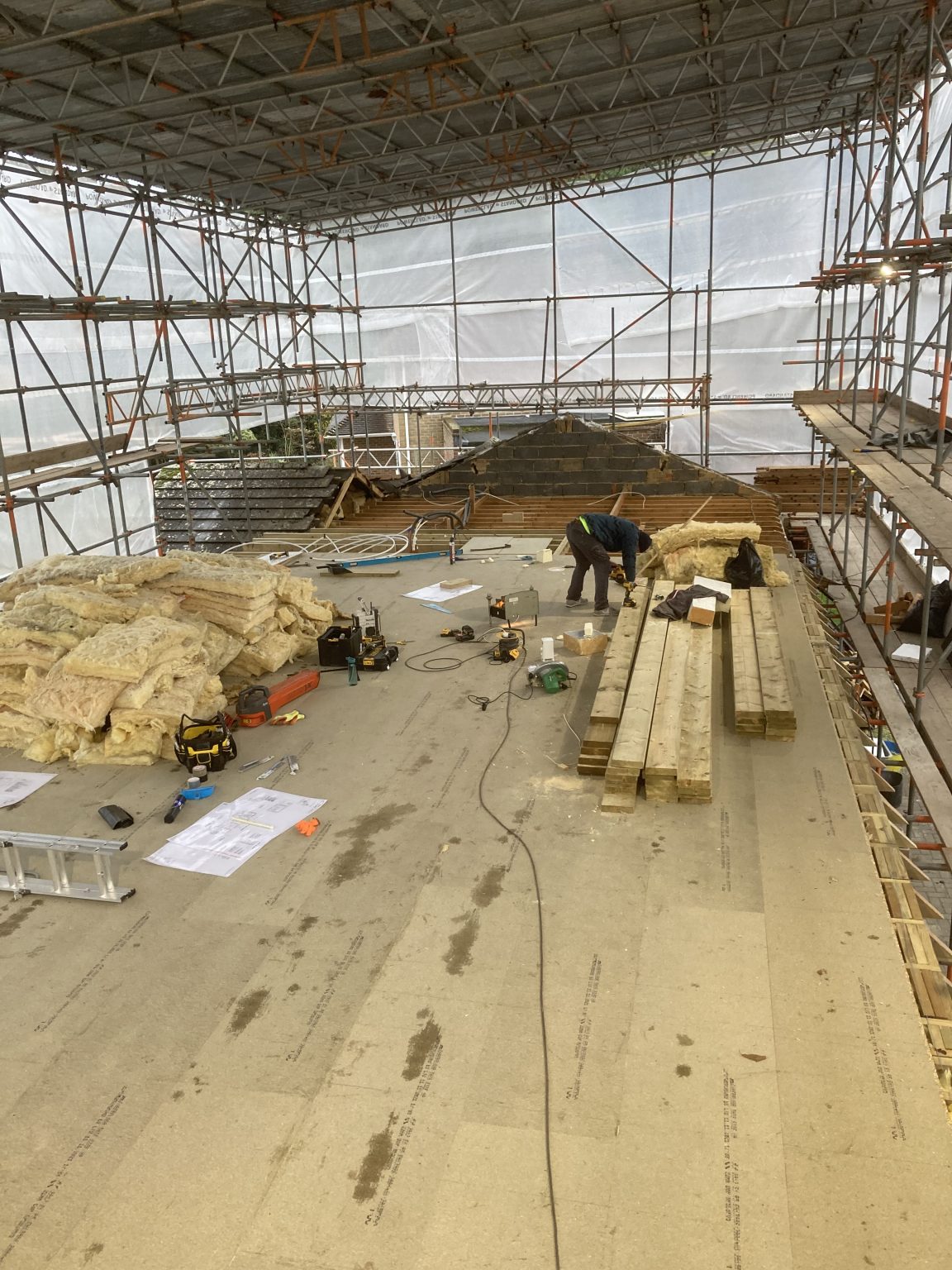 New first-floor deck being formed beneath a scaffold roof