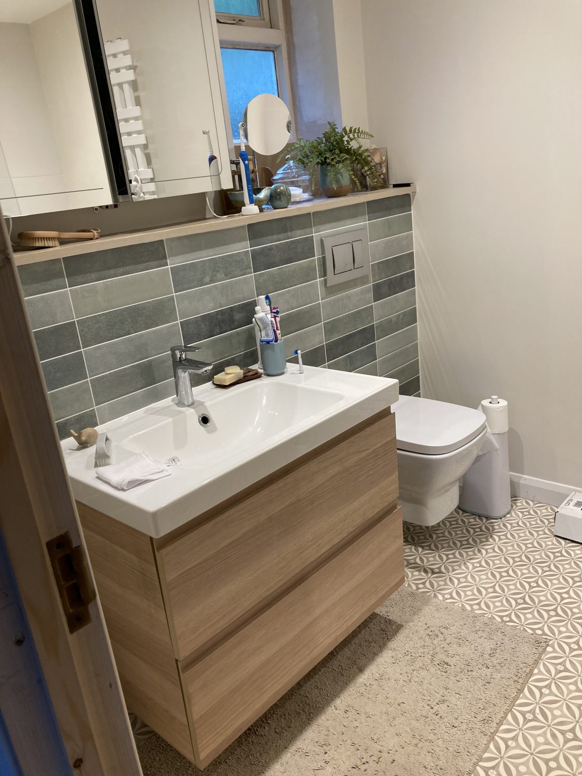 Tiled bathroom with a wood-finish wall-hung vanity and concealed cistern