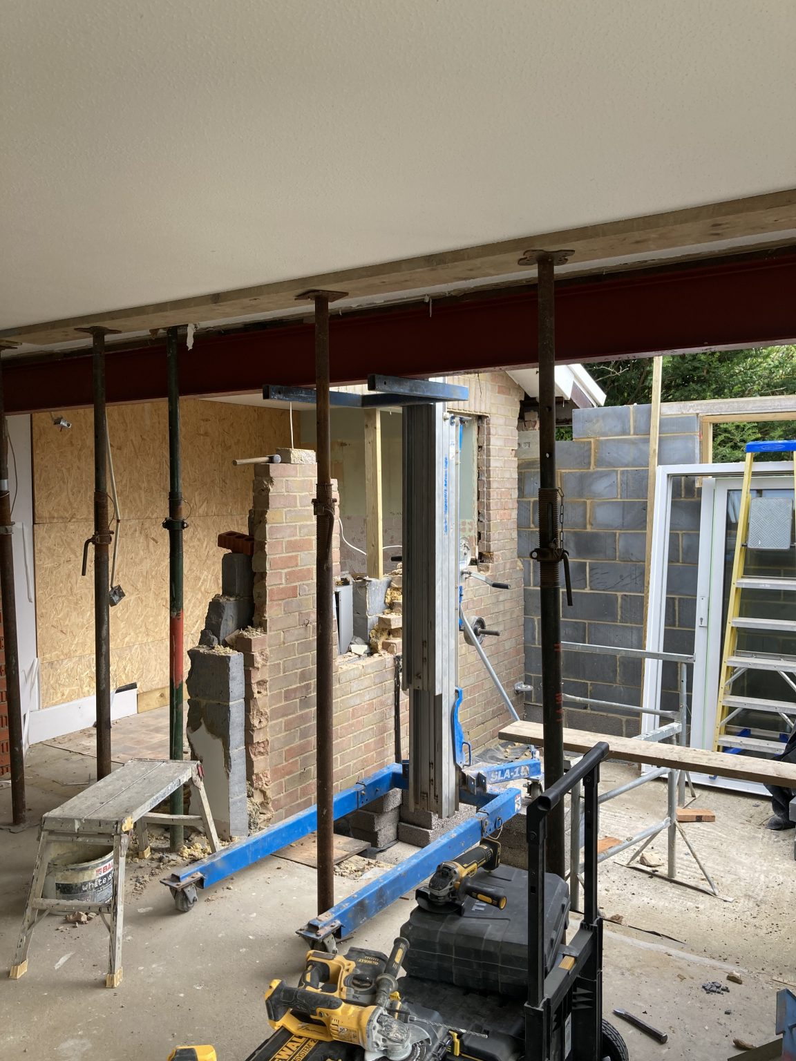 New steel beam supported on temporary props while a wall is opened up